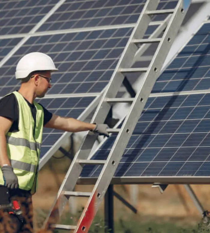 Technician with ladder working on a rooftop solar installation